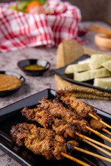 Pork Satay or Sate Babi. Pork Satay served with a Peanut sauce and slices of lontong or ketupat (rice cakes)