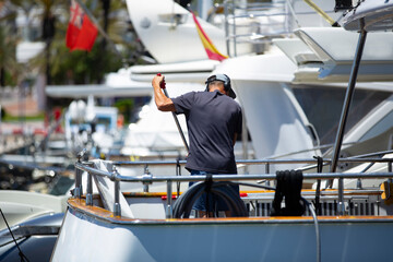 maintenance worker cleaning a yacht docked on the dock