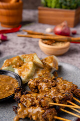Pork Satay or Sate Babi. Pork Satay served with a Peanut sauce and slices of lontong or ketupat (rice cakes)