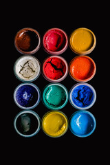 Dried gouache paint set isolated on black background