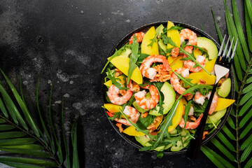 Fresh Shrimps, Mango and Avocado Salad with Walnut, Spinach and Arugula. Top view, gray table