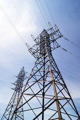 Electricity pylon, electrical transmission tower, against blue sky background.
