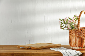 Table background of free space and picnic basket. White wall background and shadows od sun light. 