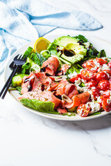 Fish salad with avocado, tomato, cucumber and onion. Keto diet recipe, Mediterranean cuisine.