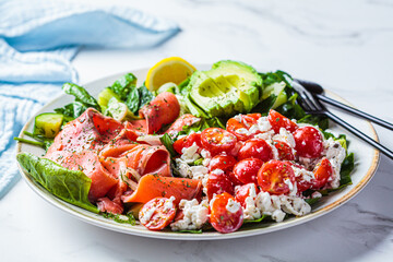 Fish salad with avocado, tomato, cucumber and onion. Keto diet recipe, Mediterranean cuisine.
