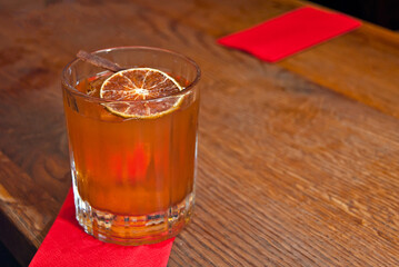 Yellow cocktail on bar counter. Whiskey, rum or brandy on a background of bar interior. Glass with...