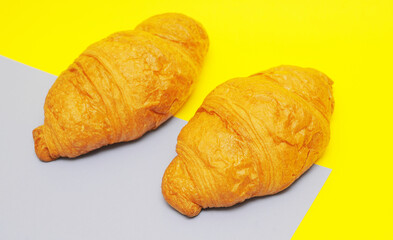 Fragrant french croissant on a yellow background. Delicious sweet pastries 