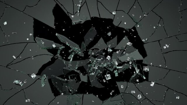 Shards of broken glass are scattered by the impact of the stone.
