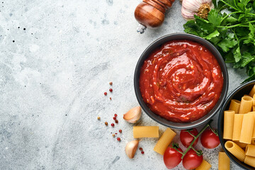Tomato ketchup spicy sauce with ingredients parsley, garlic and pepper in a black bowl with spices...