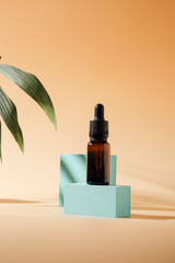 Bottled serum, oil cosmetics with sunlight on beige background, copy space