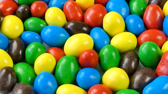 Colored peanuts in milk chocolate and sugar shells rotate 360 degrees