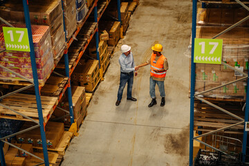 Supervisor and male worker at meeting in warehouse