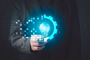 Digital transformation concept. Hand holding light bulb modern interface futuristic blue gear digital and binary coded background. Connection next generation technology and new era of innovation.