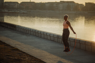 Young woman training with a jumping rope outdoors