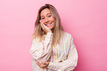 Young australian woman isolated laughs happily and has fun keeping hands on stomach.