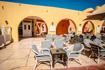 Outdoor cafe in Hurghada, Egypt. Empty gray chairs. No visitors