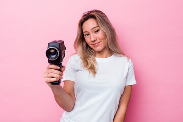 Young australian woman filming with a vintage video camera isolated
