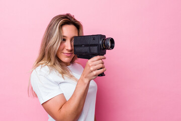 Young australian woman filming with a vintage video camera isolated