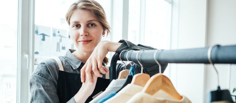 Portrait of handsome woman fashion designer standing at her workshop near railing