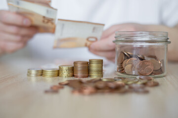Young  man sitting at table, counting savings, financial crisis.