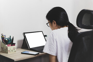Asian woman working on laptop computer at home.