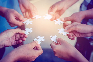 Hand of diverse people connecting jigsaw puzzle. Concept of partnership and teamwork in business