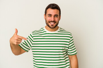 Young caucasian man isolated on white background person pointing by hand to a shirt copy space, proud and confident