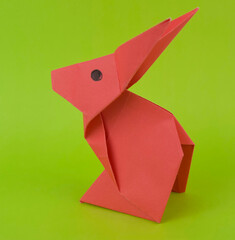 A pair of little rabbit made with small craft paper and nicely placed on a paper background