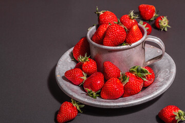 Concept of summer food with a strawberry on a black stone background
