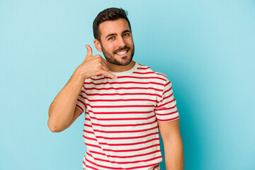 Young caucasian man isolated on blue background showing a mobile phone call gesture with fingers.