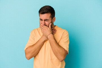 Young caucasian man isolated on blue background suffers pain in throat due a virus or infection.