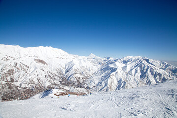 Fototapeta premium Skifahren in Darbandsar im Iran. Im Hintergrund ist der Damavand, der höchste Berg des Iran, im Albers-Gebirge zu sehen. 