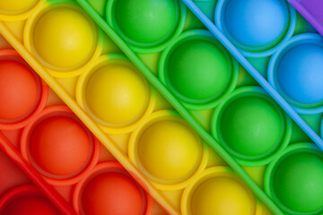 Rainbow isometric pattern of silicon toy for kids close up. Pop it fidget toy. Simple dimple toy detail. 