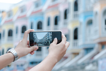 Young people take pictures of the buildings in the city Phuket, thailand. Travel concepts and technology.