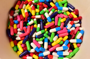Fototapeta na wymiar Multi-colored pills in capsules. Multicolored pharmaceutical pills, medical tablets and capsules. Medical pill for maintaining and improving health. Concept of healthcare and medicine