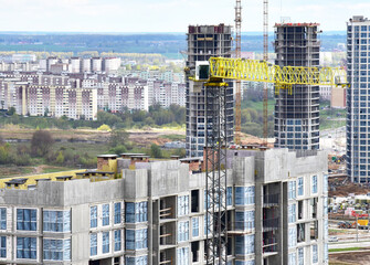 Tower crane during construction of a residential building. Cranes on formworks. Construction the building or multi-storey homes, Arial view. Real Estate and Renovation concept. Housing project