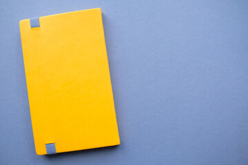 Bright yellow notebook on a solid dark background