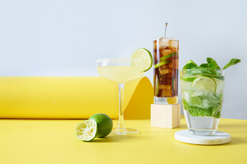 Classic mojito, cuba libre, margarita cocktail with lime and lemon in modern still life on color...