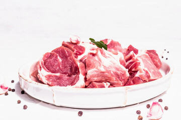 Diced raw pork meat with dry sumac, fresh garlic, and basil leaves