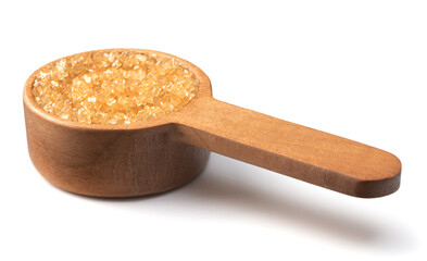 yellow sanding sugar in the wooden measuring spoon, isolated on white background