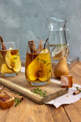 summer drink with a pear in a glass on a wooden background
