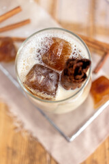 summer drink with milk and coffee ice cubes in a glass on a wooden background