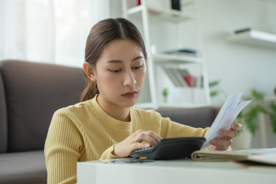 stressed young asian woman trying to find money to pay credit card deb