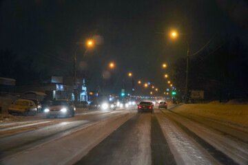 Fototapeta na wymiar Cars in traffic in winter in the evening dark