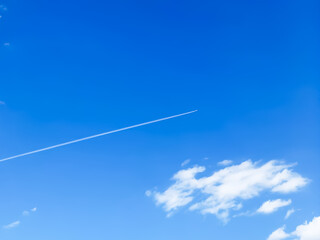 airplane in a blue sky with a cloud