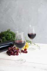 red wine and grapes on white wooden table