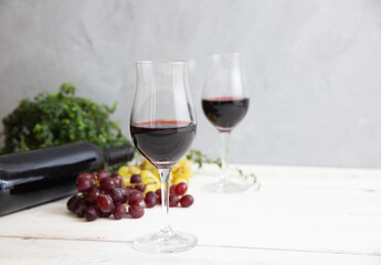 red wine and grapes on white wooden table