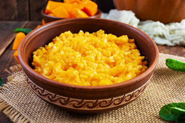Delicious homemade pumpkin porridge on wooden background. Healthy vegan food