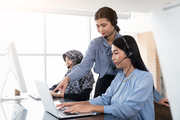 Obraz premium Group of professional call center employees Talking to customers with headsets. Friendly operator or helpdesk agent are assisting remote customers and consulting client by remortly. Soft Focus.