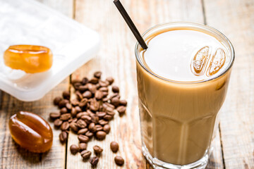 iced coffee with beans for cold summer drink on wooden background